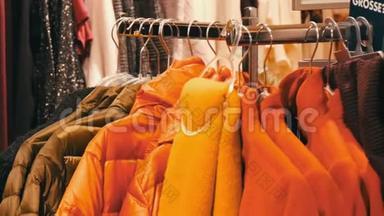 时尚温暖的衣服挂在一家商场的服装店的衣架上。
